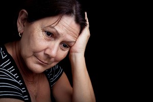 Portrait of a sad, depressed older woman, isolated on black