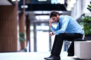 A man sitting on a bench looking frustrated