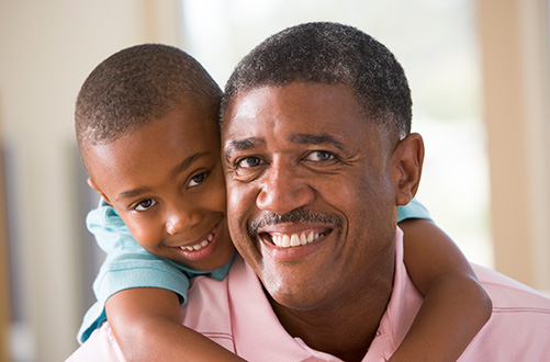 A grandfather and grandson smiling at the camera.