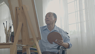 older man at an easel painting