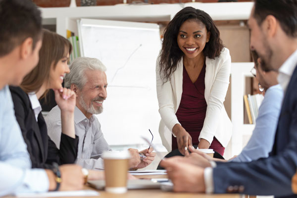 A group of five people in a meeting around a table.